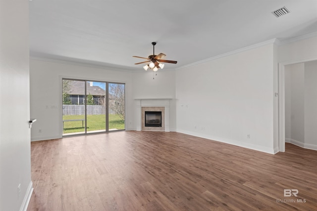 unfurnished living room with visible vents, crown molding, and wood finished floors