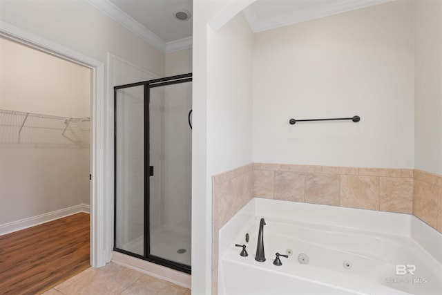 full bath with a walk in closet, a shower stall, crown molding, and a whirlpool tub