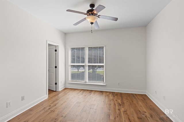 empty room with a ceiling fan, wood finished floors, and baseboards