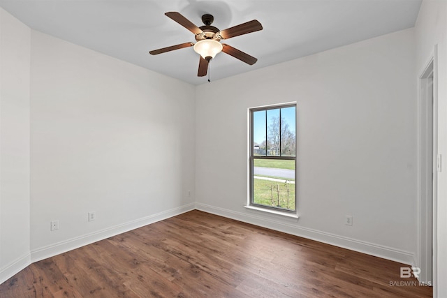 empty room with dark wood finished floors, baseboards, and ceiling fan