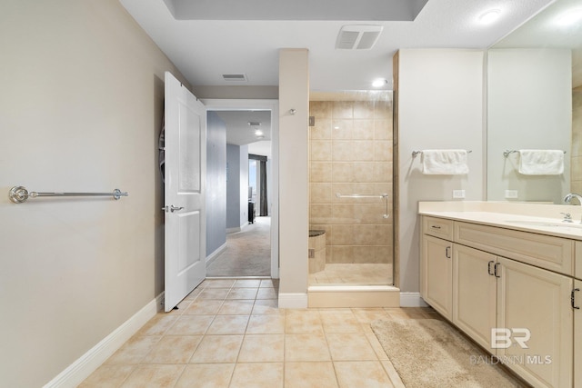 bathroom featuring tile patterned flooring, vanity, and a shower with shower door