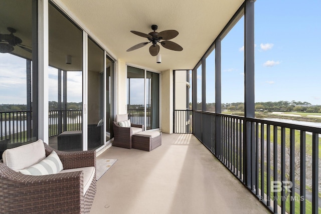 sunroom / solarium with a water view and ceiling fan