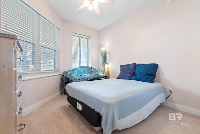 carpeted bedroom featuring multiple windows and ceiling fan