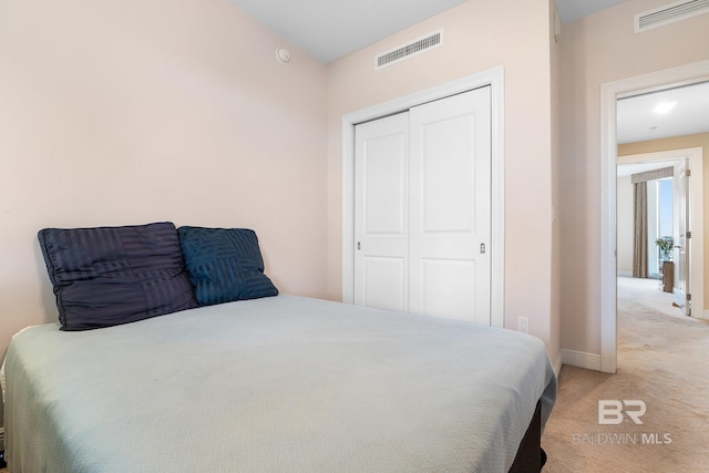 bedroom featuring light carpet and a closet