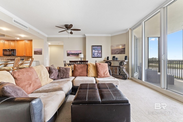 carpeted living room with ornamental molding and ceiling fan