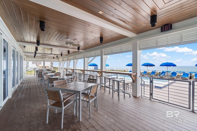 interior space with a water view, wooden ceiling, and ceiling fan