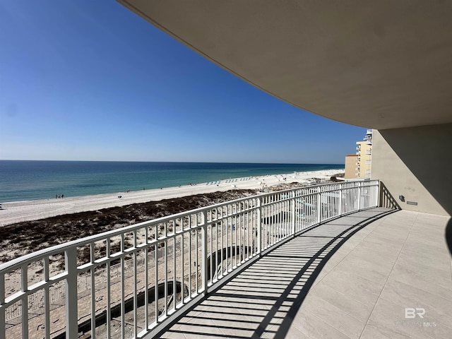 balcony featuring a beach view and a water view