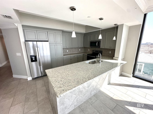 kitchen featuring a peninsula, gray cabinets, stainless steel appliances, and a sink