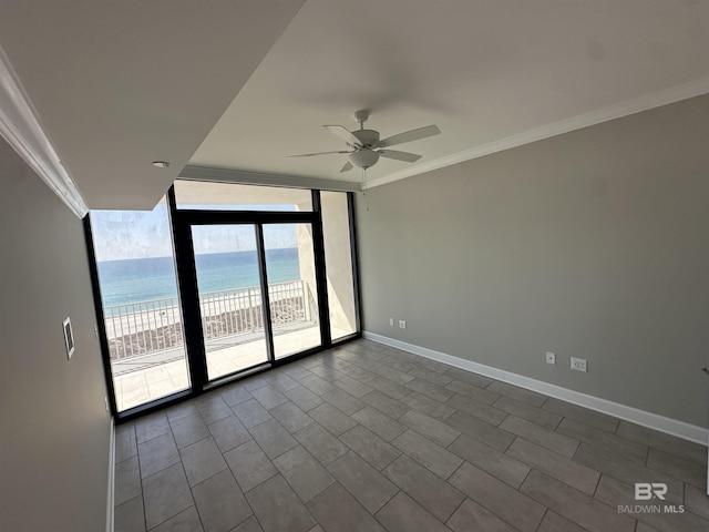 unfurnished room with baseboards, a ceiling fan, ornamental molding, a water view, and floor to ceiling windows