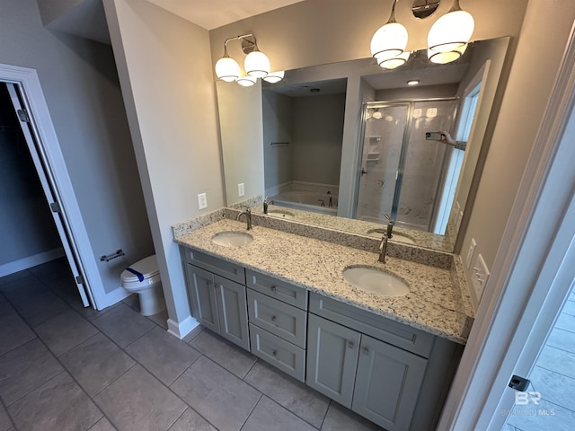 full bath with toilet, a stall shower, a garden tub, and a sink