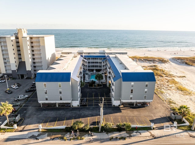 drone / aerial view featuring a water view and a beach view