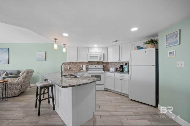 kitchen featuring white appliances, white cabinetry, sink, and decorative backsplash