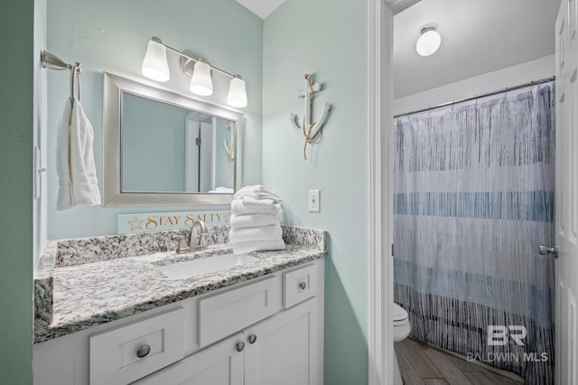 bathroom featuring vanity, toilet, hardwood / wood-style flooring, and a shower with shower curtain