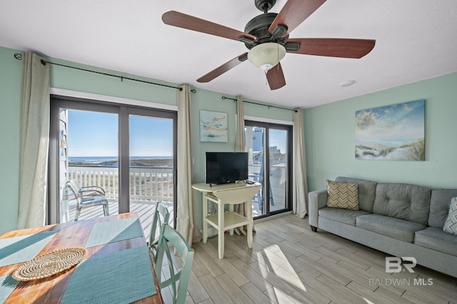 living room with light hardwood / wood-style flooring and ceiling fan