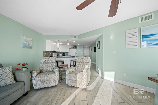 living room featuring light hardwood / wood-style flooring and ceiling fan