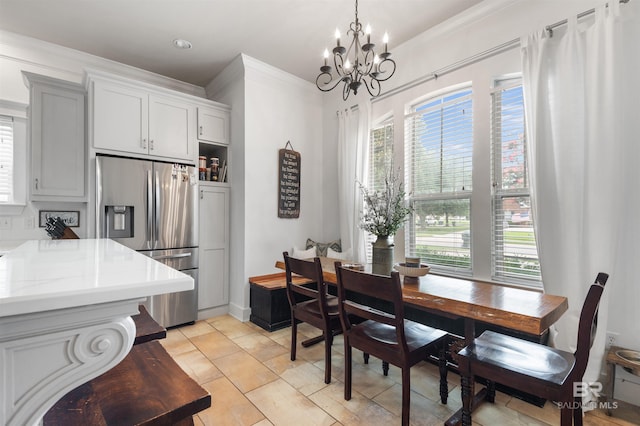 tiled dining space featuring ornamental molding and a chandelier