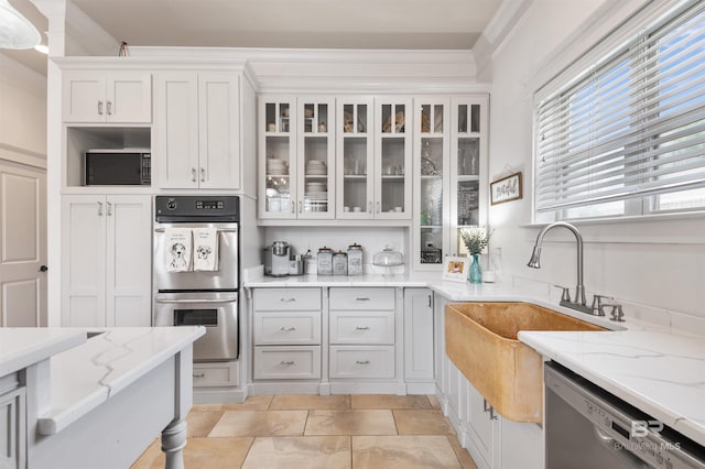 kitchen with sink, light stone counters, crown molding, white cabinets, and appliances with stainless steel finishes