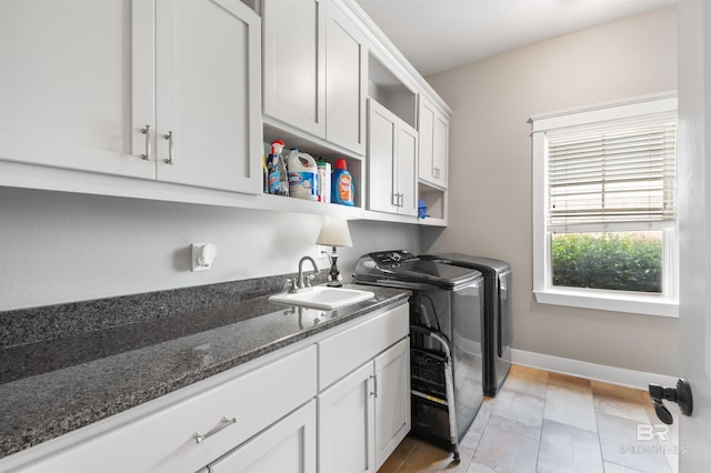 laundry area with sink, cabinets, and independent washer and dryer