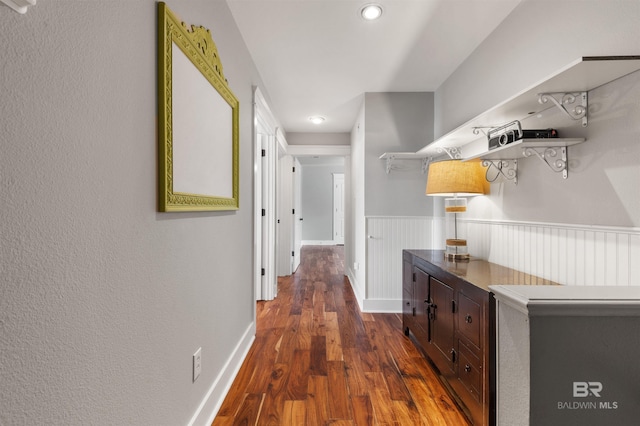 corridor with dark hardwood / wood-style flooring