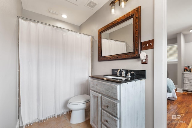 bathroom with vanity, wood-type flooring, and toilet