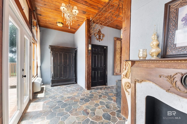 entryway with a notable chandelier, lofted ceiling, wooden ceiling, and french doors