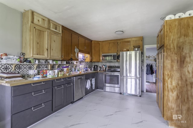 48851 Colt Run, Bay Minette, AL 36507 - kitchen with stainless steel appliances, light marble finish flooring, backsplash, a sink, and brown cabinets