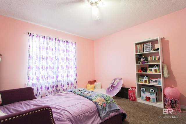 bedroom with ceiling fan, carpet floors, and a textured ceiling