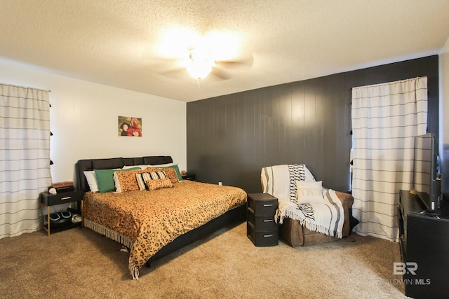 carpeted bedroom featuring ceiling fan and a textured ceiling