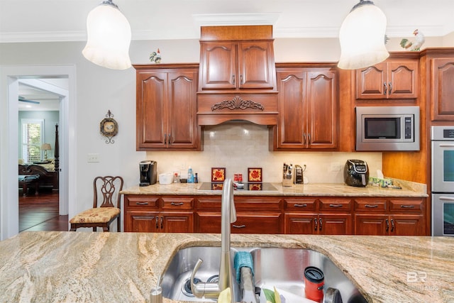 kitchen featuring decorative light fixtures, light stone countertops, stainless steel appliances, wood-type flooring, and tasteful backsplash