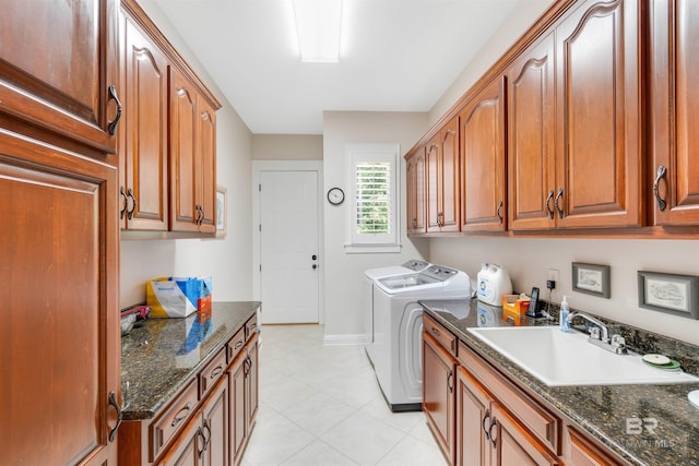 laundry area featuring washing machine and clothes dryer, cabinets, sink, and light tile patterned floors