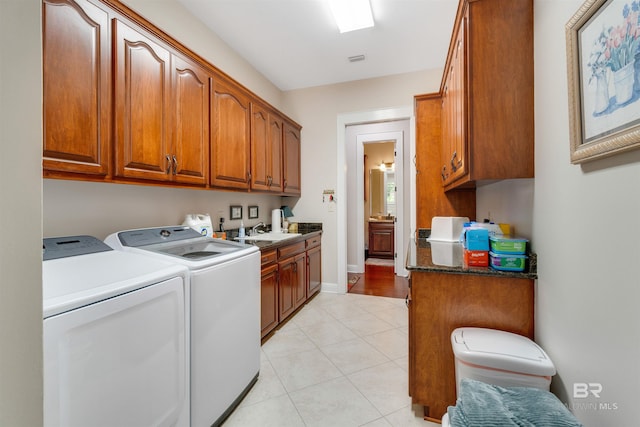 washroom featuring cabinets, washing machine and dryer, sink, and light hardwood / wood-style floors