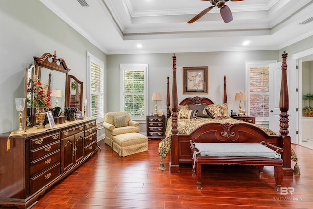 bedroom with crown molding, a raised ceiling, ceiling fan, and dark hardwood / wood-style floors