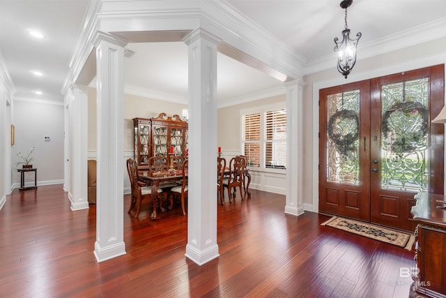 entrance foyer with crown molding, dark wood-type flooring, a wealth of natural light, and ornate columns