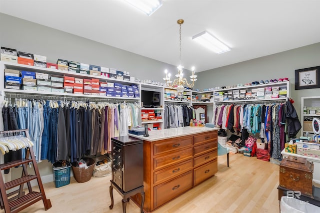 spacious closet featuring a chandelier and light hardwood / wood-style floors