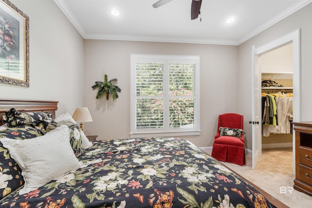 bedroom with ornamental molding, ceiling fan, a closet, a walk in closet, and light colored carpet