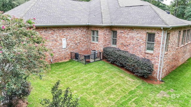 back of house featuring a yard and cooling unit