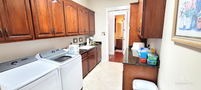 clothes washing area with light tile patterned floors, cabinets, sink, and independent washer and dryer