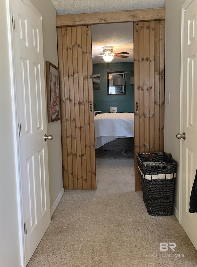hallway featuring carpet flooring and a textured ceiling