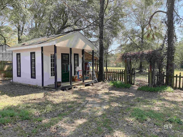 view of outdoor structure with fence and an outbuilding