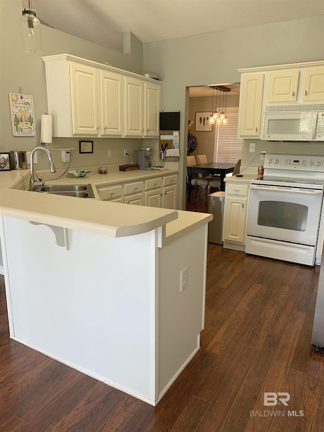 kitchen featuring a sink, light countertops, a peninsula, white appliances, and white cabinetry