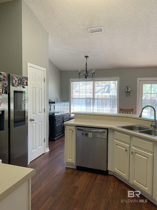 kitchen with a notable chandelier, appliances with stainless steel finishes, a sink, a textured ceiling, and visible vents