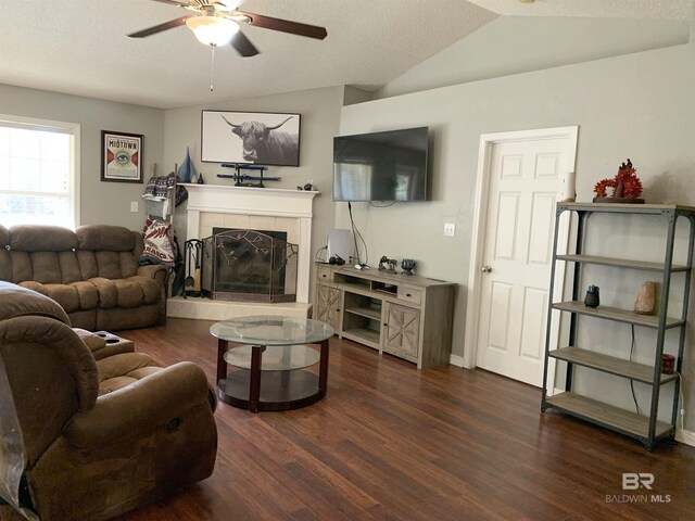 living room featuring ceiling fan, wood finished floors, vaulted ceiling, and a fireplace