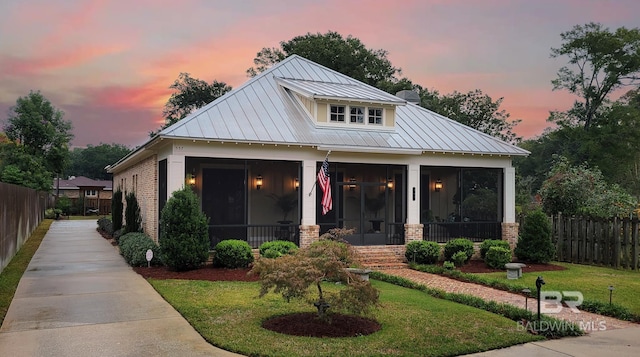 modern farmhouse featuring a sunroom and a yard