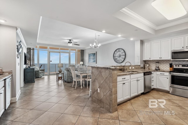 25494 Perdido Beach Blvd Unit 2005, Orange Beach, AL 36561 - kitchen with decorative backsplash, appliances with stainless steel finishes, a sink, light tile patterned floors, and ornamental molding