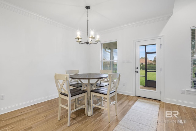 dining space featuring ornamental molding, light hardwood / wood-style flooring, and a chandelier