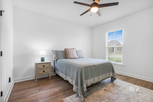 bedroom with dark hardwood / wood-style flooring and ceiling fan