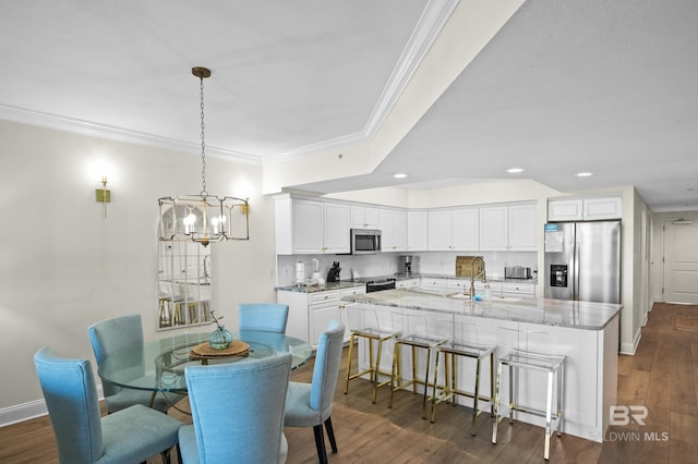 dining space with sink, dark hardwood / wood-style floors, and ornamental molding