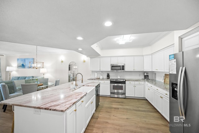 kitchen with white cabinets, light stone countertops, a kitchen island with sink, and appliances with stainless steel finishes