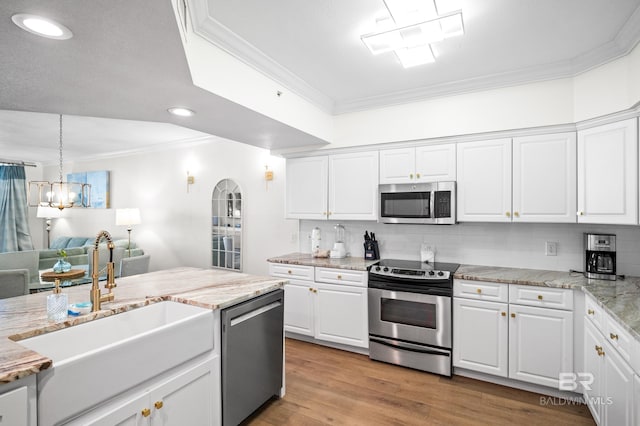 kitchen featuring white cabinets, decorative light fixtures, appliances with stainless steel finishes, and sink