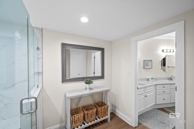 bathroom with wood-type flooring, an enclosed shower, and vanity